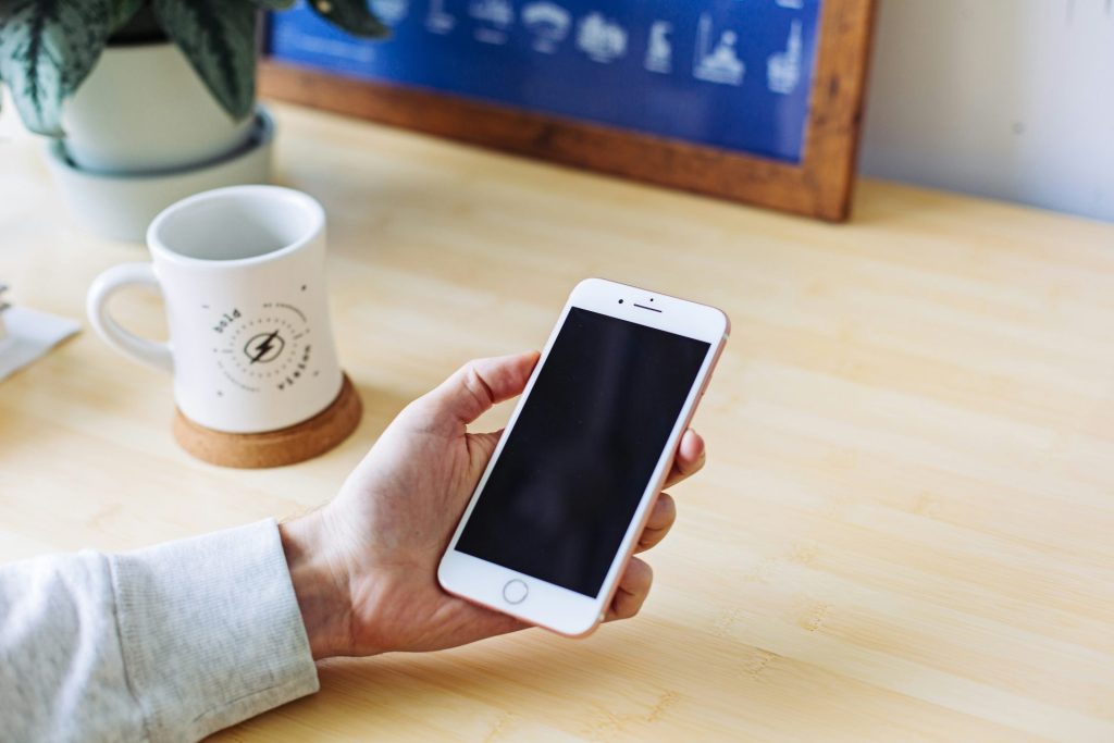 personne tenant un iPhone 6 en or rose