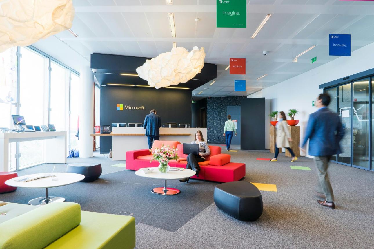 Espace de réception de bureau contemporain avec des sièges dynamiques et une ambiance professionnelle.