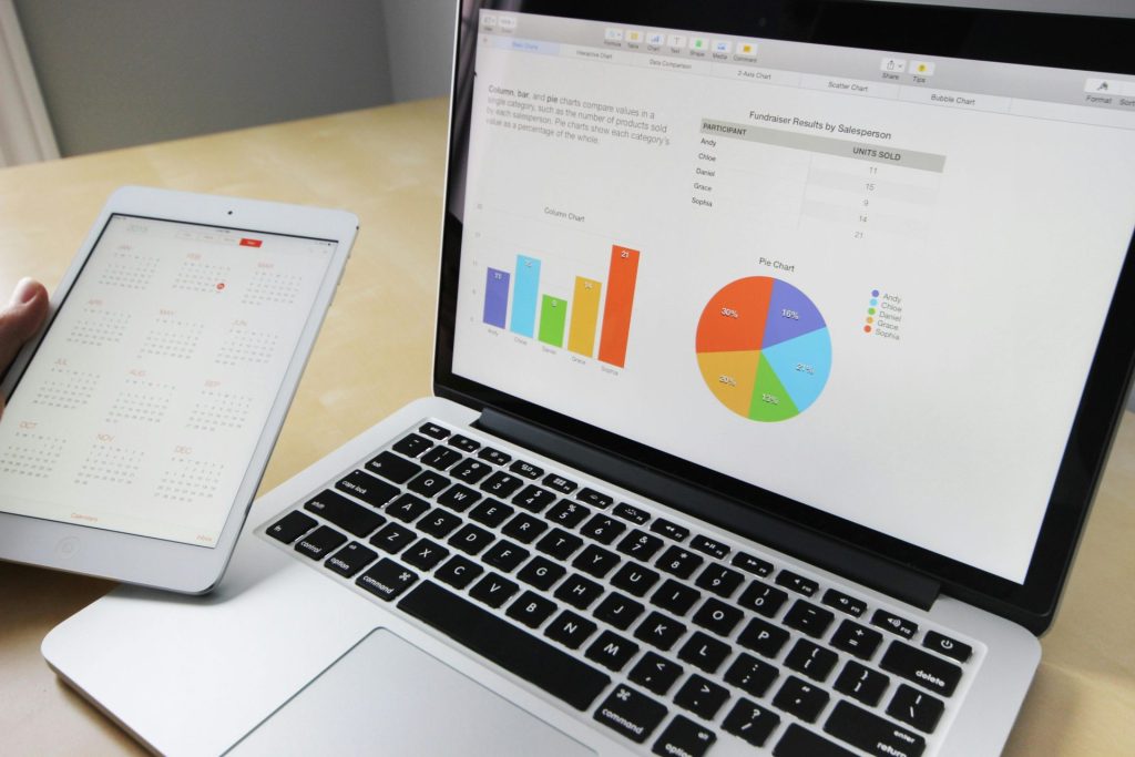 Ordinateur portable affichant des tableaux et des graphiques avec calendrier de tablette pour l'analyse et la planification des données.