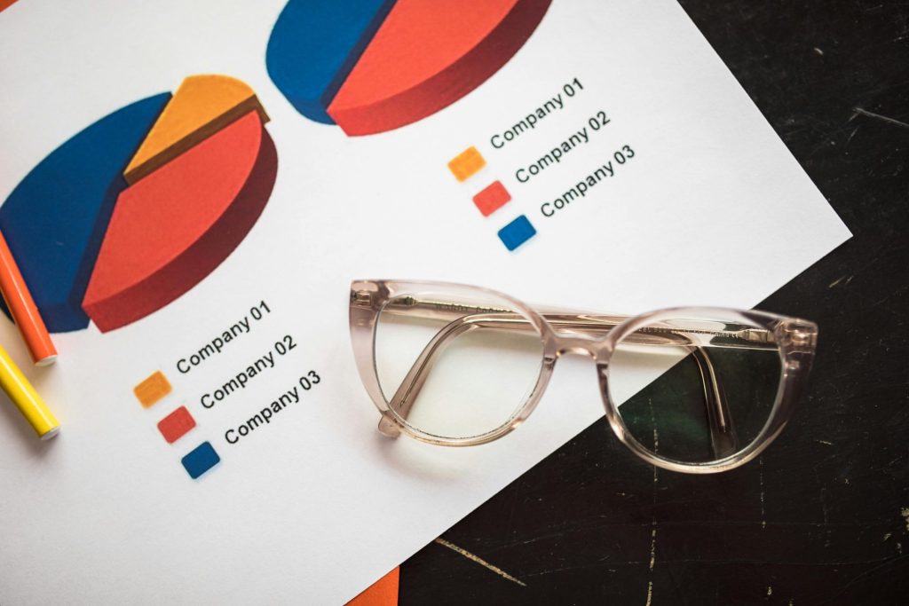 Photo de graphiques commerciaux et de lunettes sur un bureau, idéale pour les thèmes financiers et analytiques.
